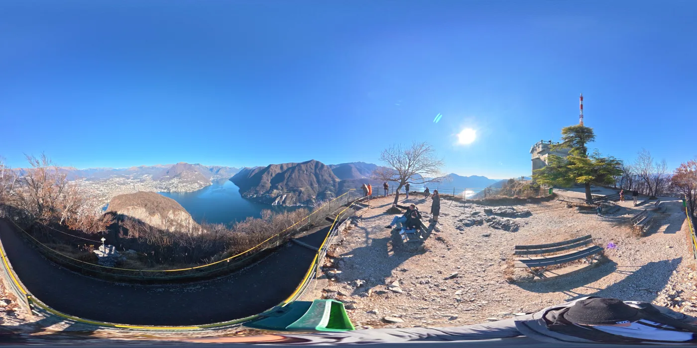 Equirectangular 360 degree panorama of people at a mountain viewpoint above a lake
